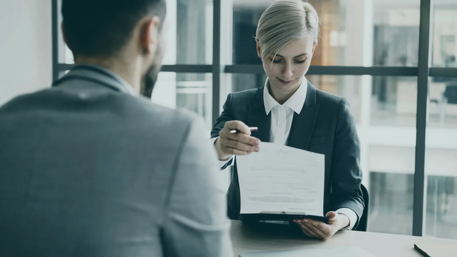 Profissional de RH confere relatórios e planilhas no computador em um escritório