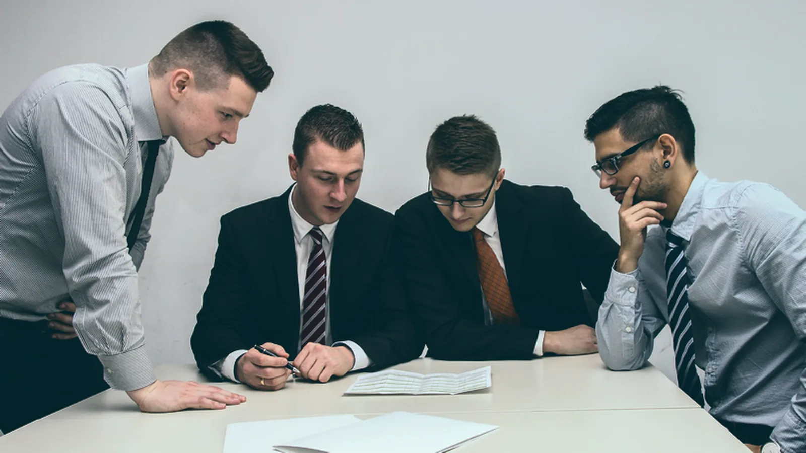 Profissional de RH analisa em reunião os resultados de um levantamento sobre organização do trabalho com a liderança da empresa
