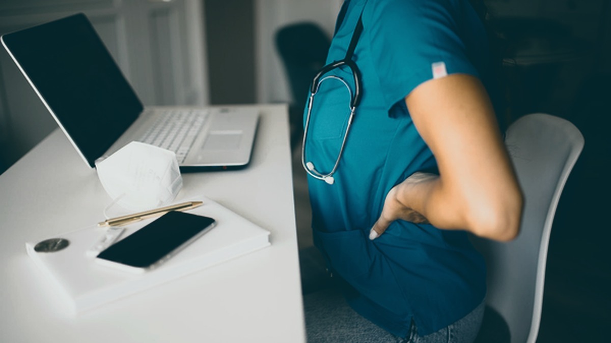 Trabalhador de escritório apresentando desconforto postural durante o uso do computador