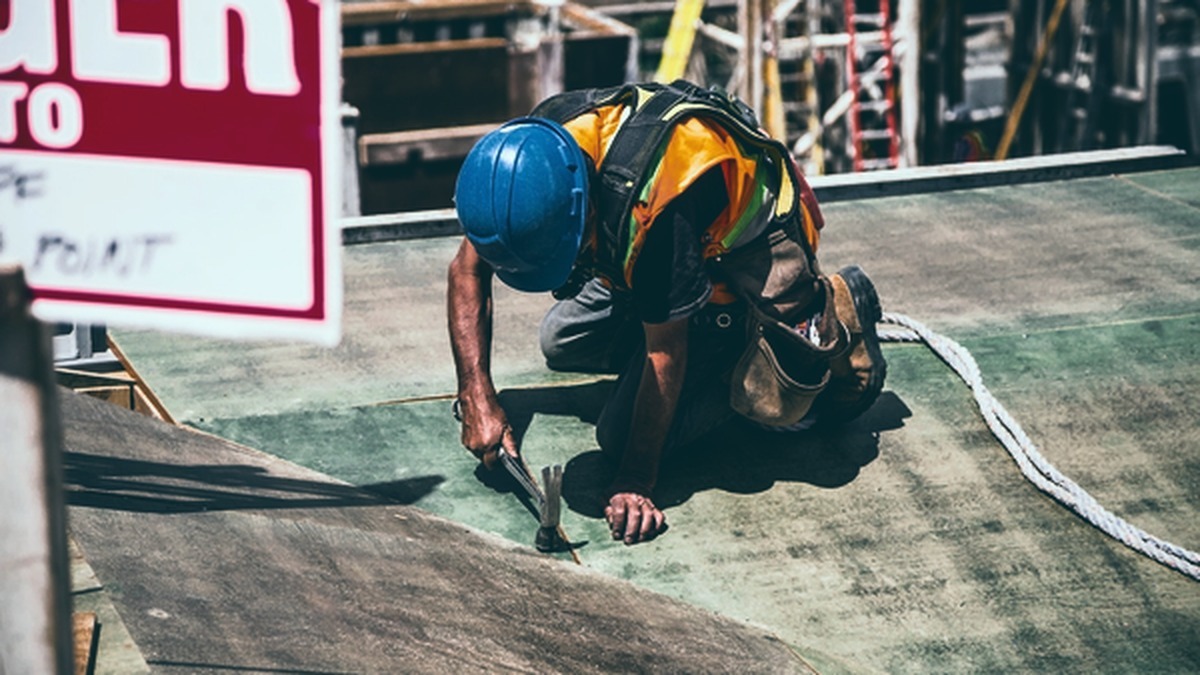 Trabalhador utilizando equipamento completo de proteção contra quedas em atividade de trabalho em altura